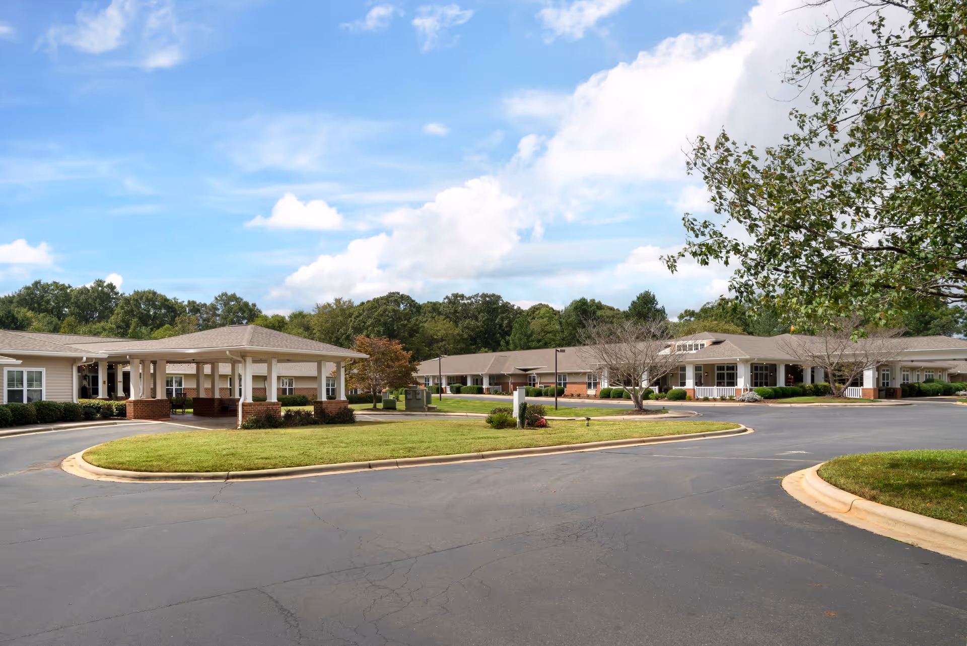 Exterior view of a Brookdale Monroe Square campus with circular driveway and low buildings.