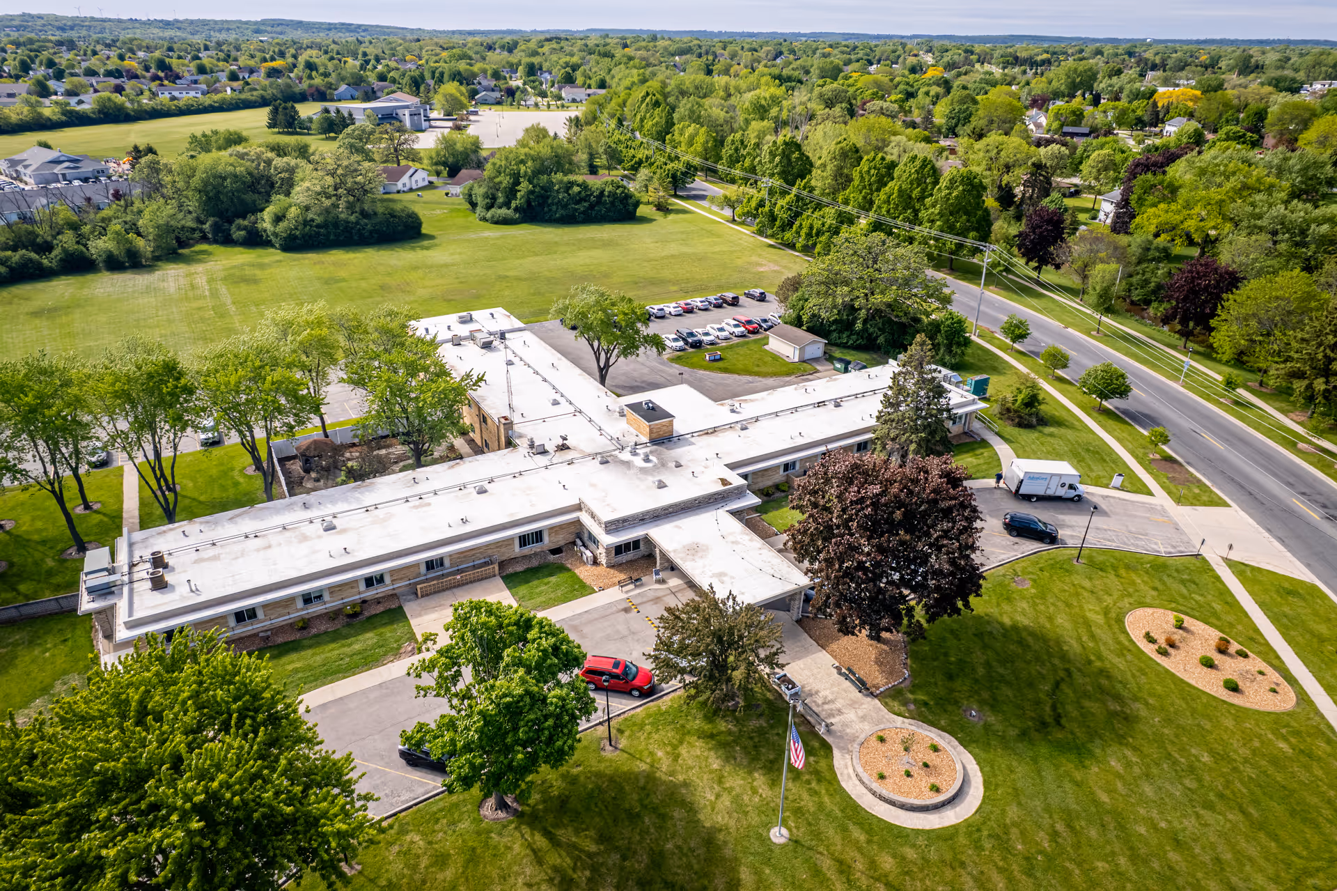 Aerial view of Edenbrook Fond du Lac senior living campus with manicured lawns and surrounding roads.