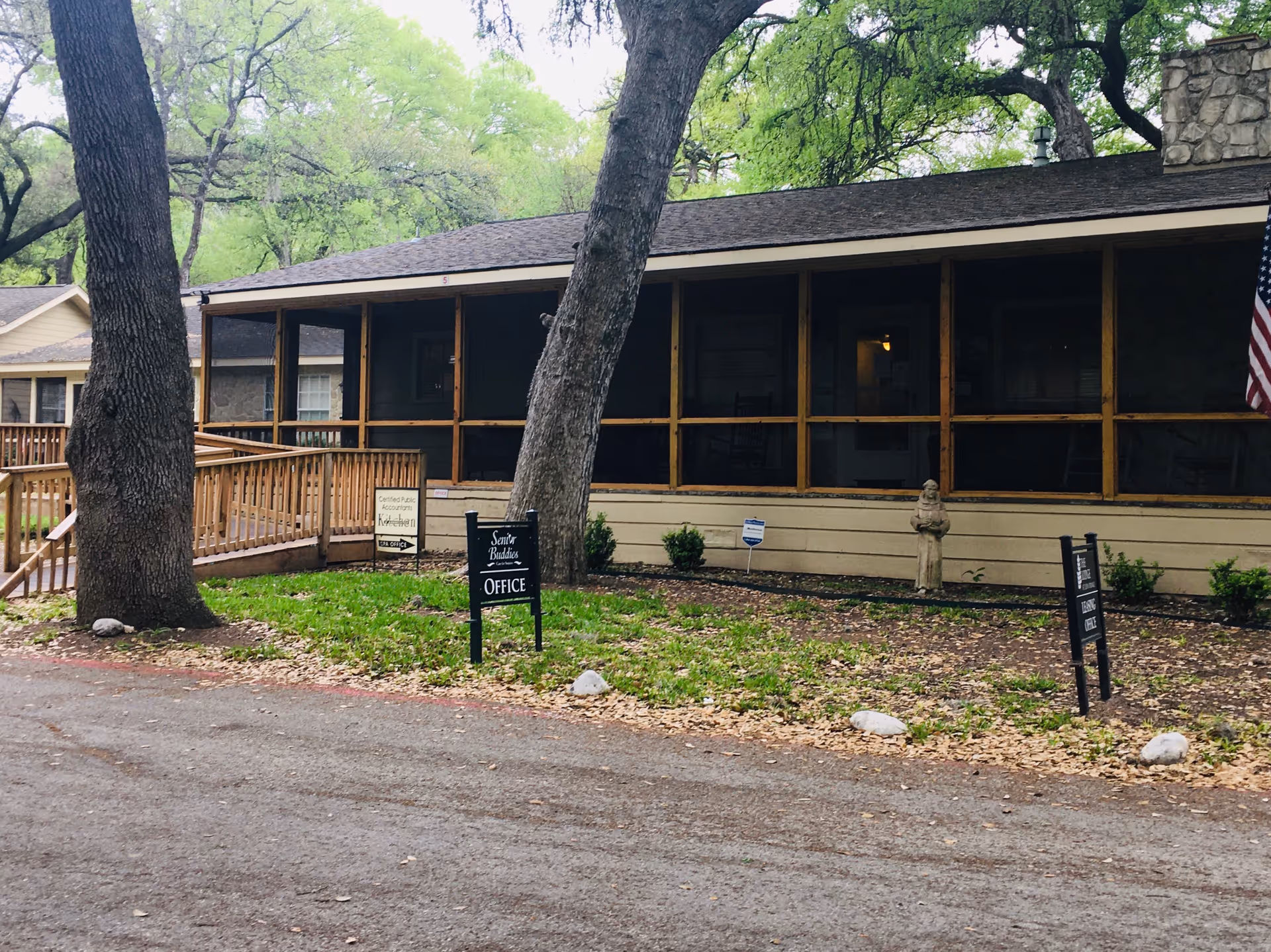 Exterior view of Senior Buddies In Home Care building with screened porch and signs.