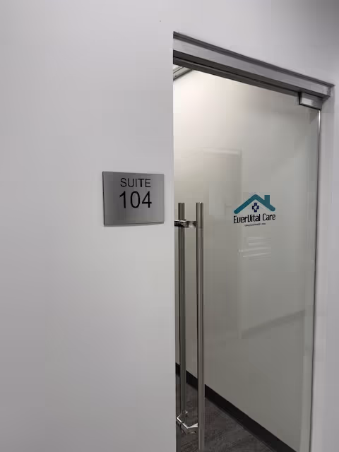 Interior glass door to Suite 104 with EverVital Care logo in a hallway.