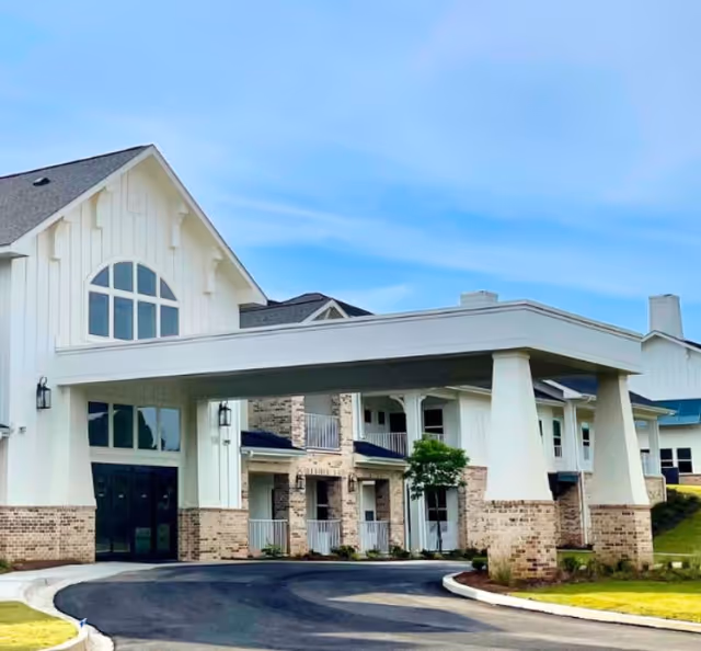 White modern senior living facility exterior with large entrance canopy