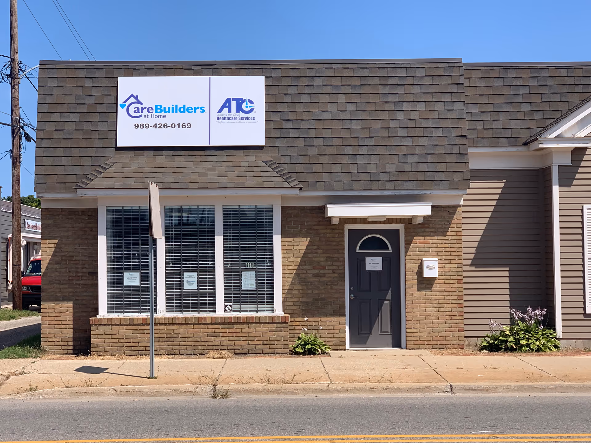 Front exterior of a CareBuilders At Home facility with brick facade, sign, and doorway.