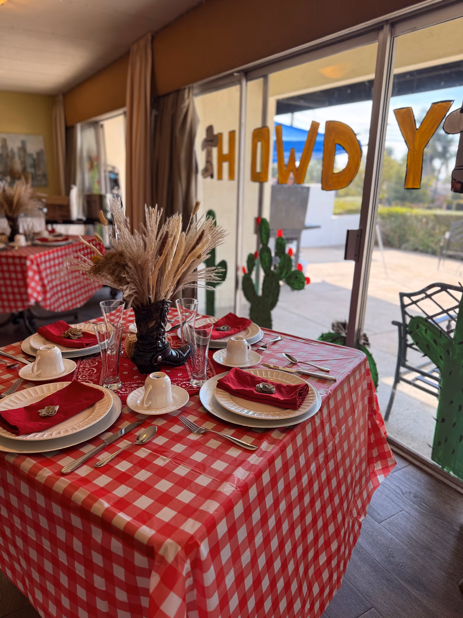 Indoor dining room with a red-checkered table set for a meal.