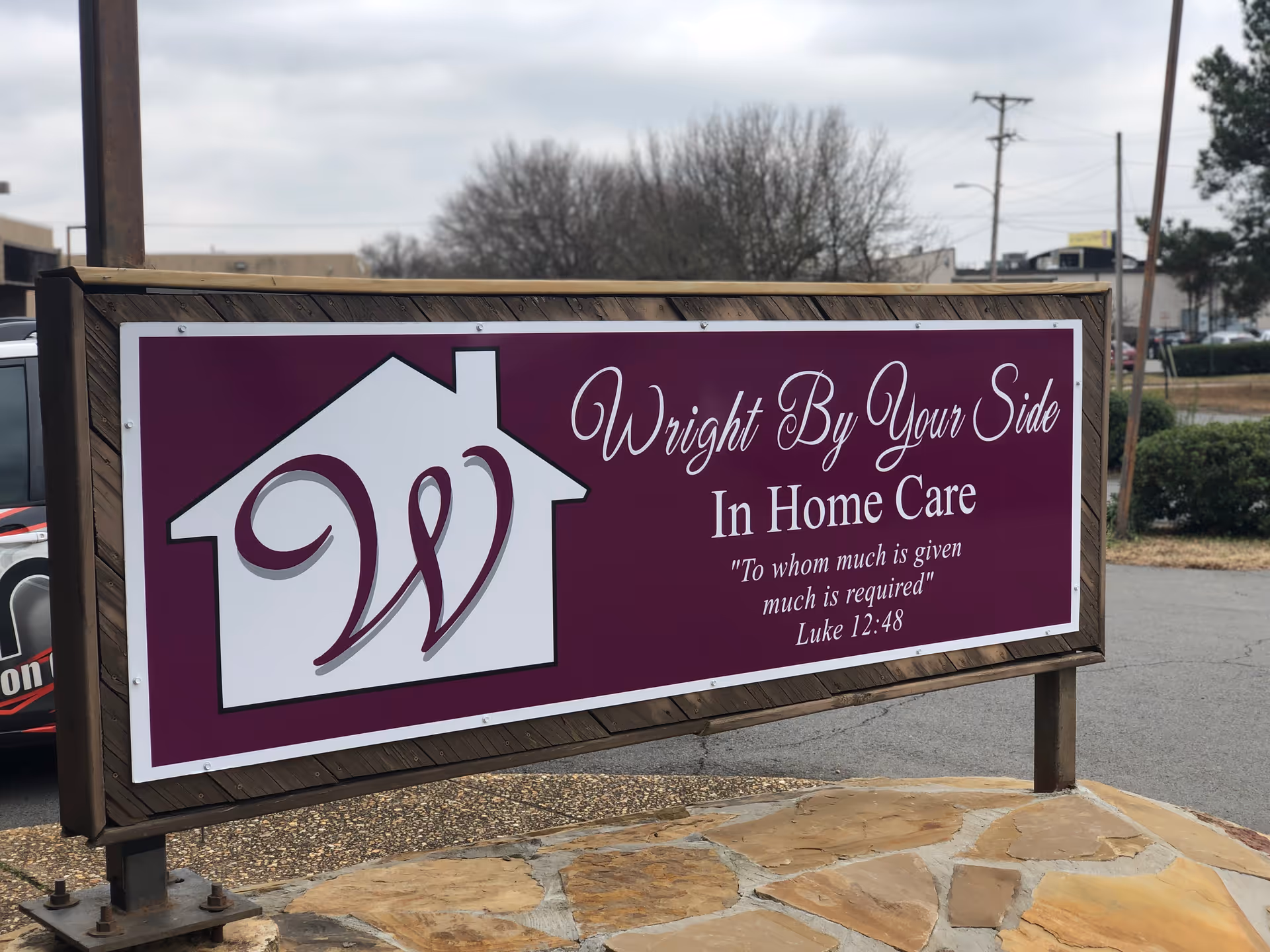 Exterior signboard for Wright By Your Side In Home Care in a parking lot.