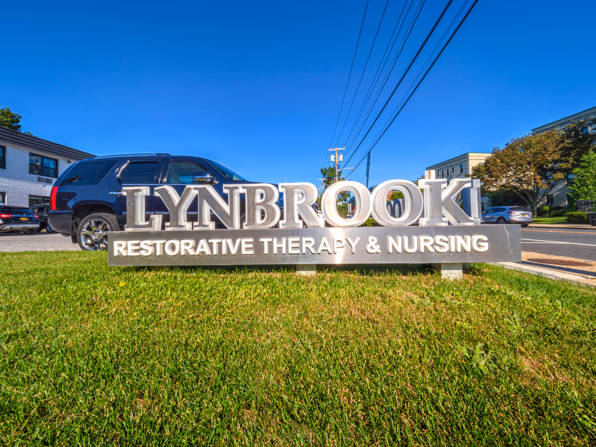 Lynbrook Restorative Therapy and Nursing sign on a grassy median in front of the building.