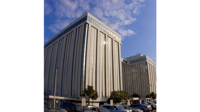 Tall modern UF Health Home Care - Jacksonville building exterior with a parking lot.