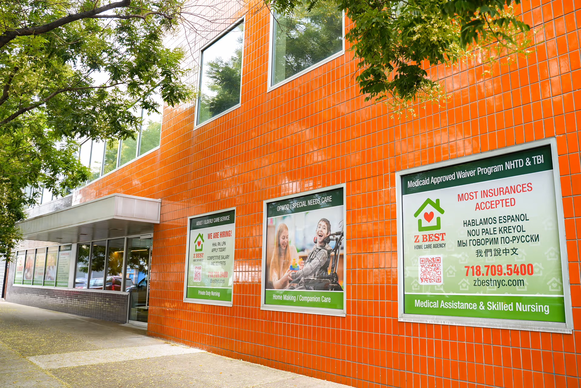 Exterior view of an orange-tiled building with large posters advertising Z Best Home Care Agency.