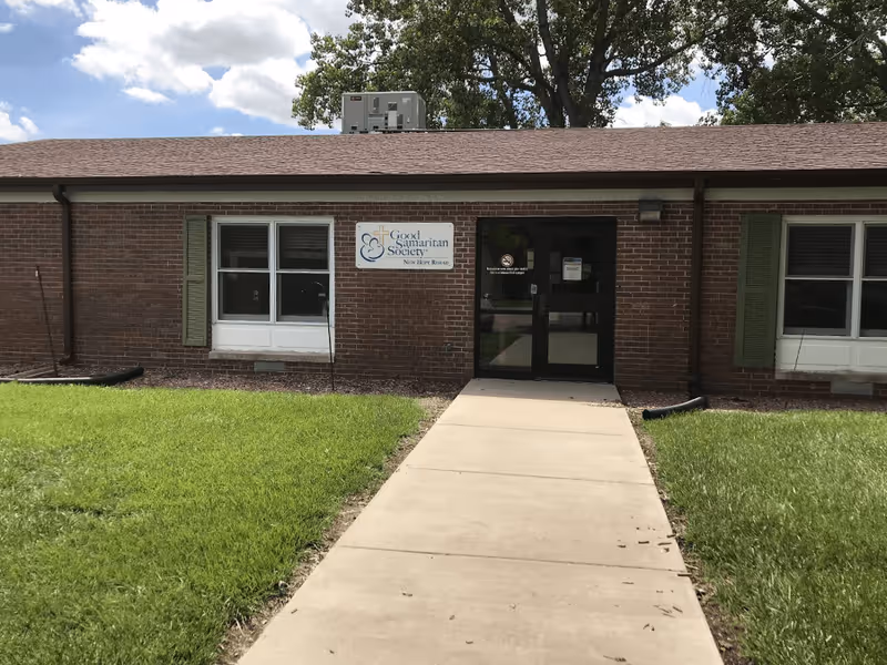 Brick building with front entrance, sign for Good Samaritan Society, and concrete walkway.