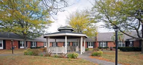 Exterior view of Richmond Place senior living facility showing a central gazebo and brick building.