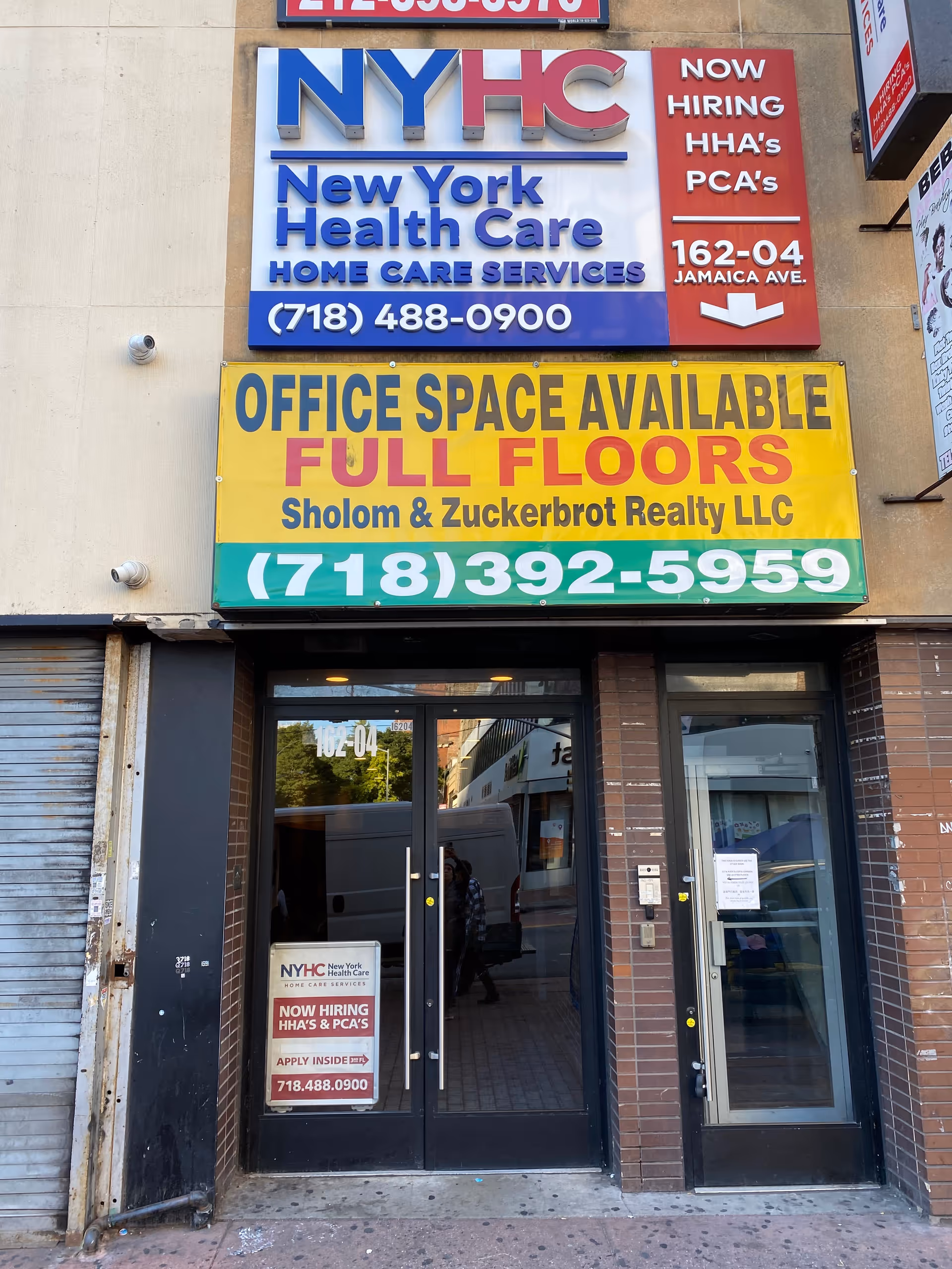 Exterior building facade with large NYHC signs and an entrance door.