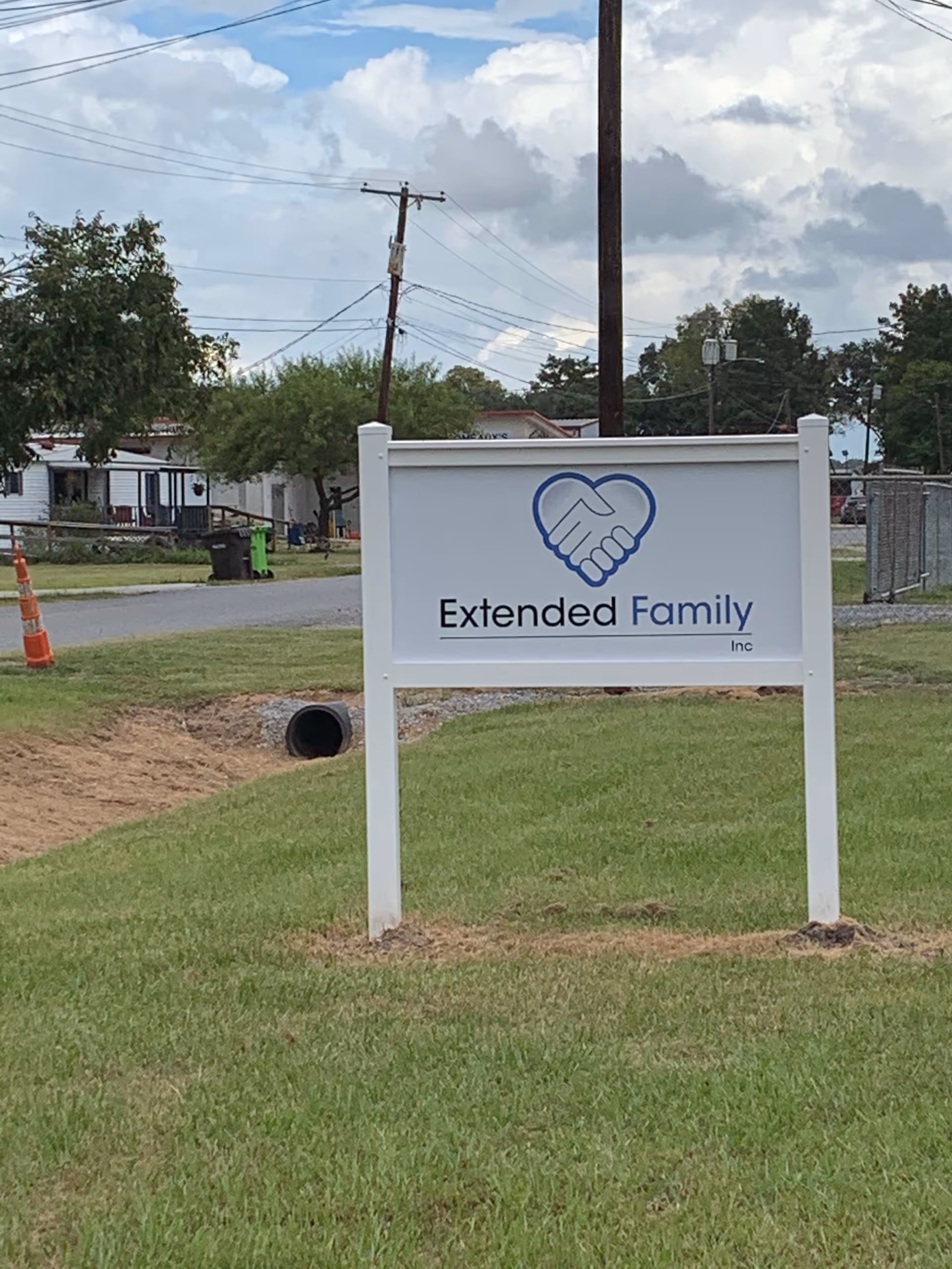 Sign for Extended Family Inc on a grassy lawn beside the road