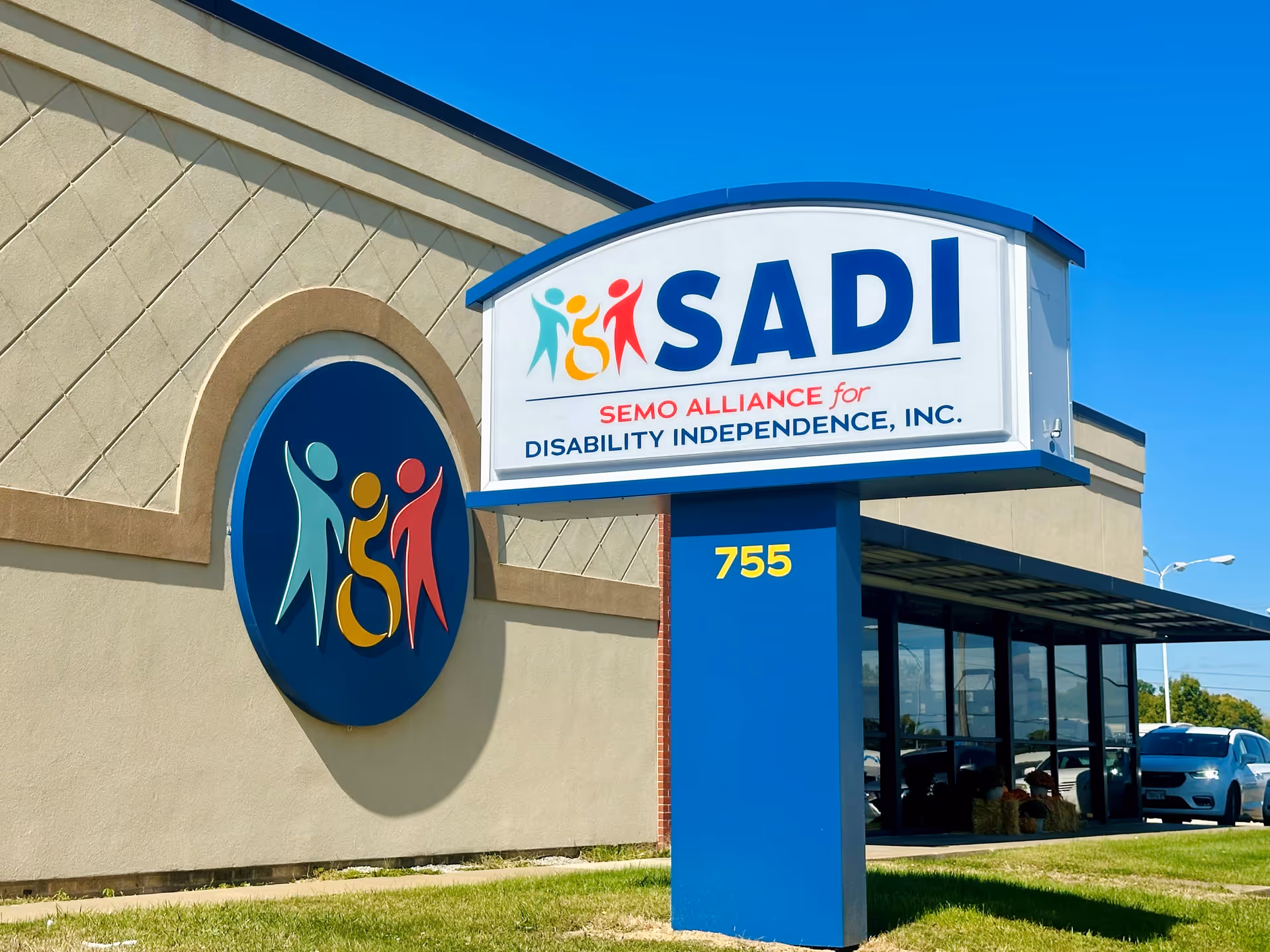 Exterior view of a building with a large SADI sign and colorful logo.