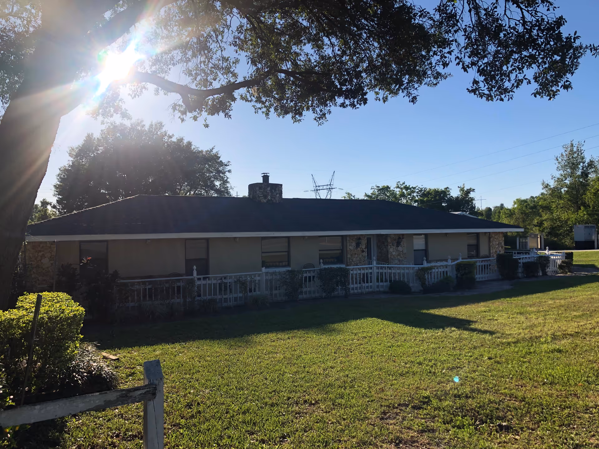 Single-story senior living facility exterior with a long porch and green lawn.