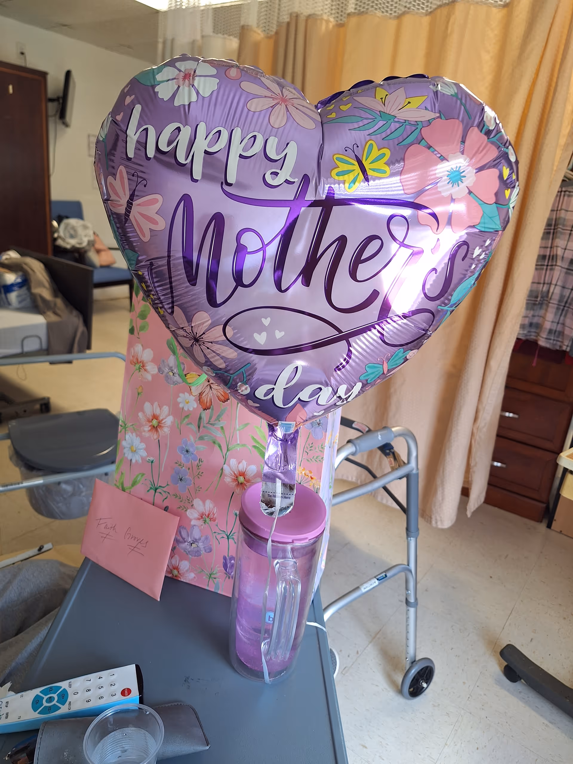 Heart-shaped Happy Mother's Day balloon in a senior care room with a walker.