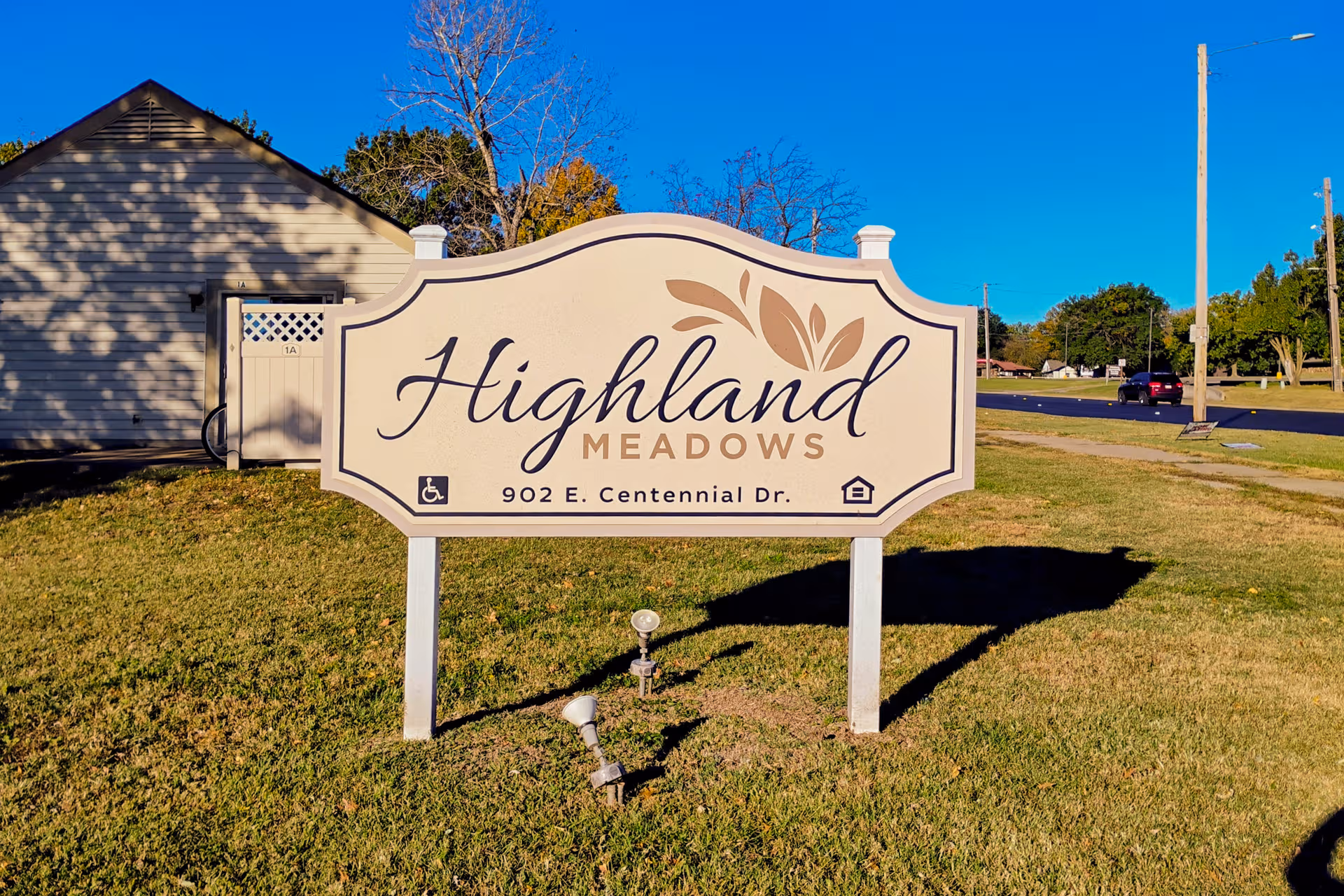 Exterior sign for Highland Meadows senior living in front of a beige building