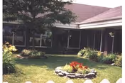 Exterior view of Brookside Senior Living Comm building with a landscaped front yard.