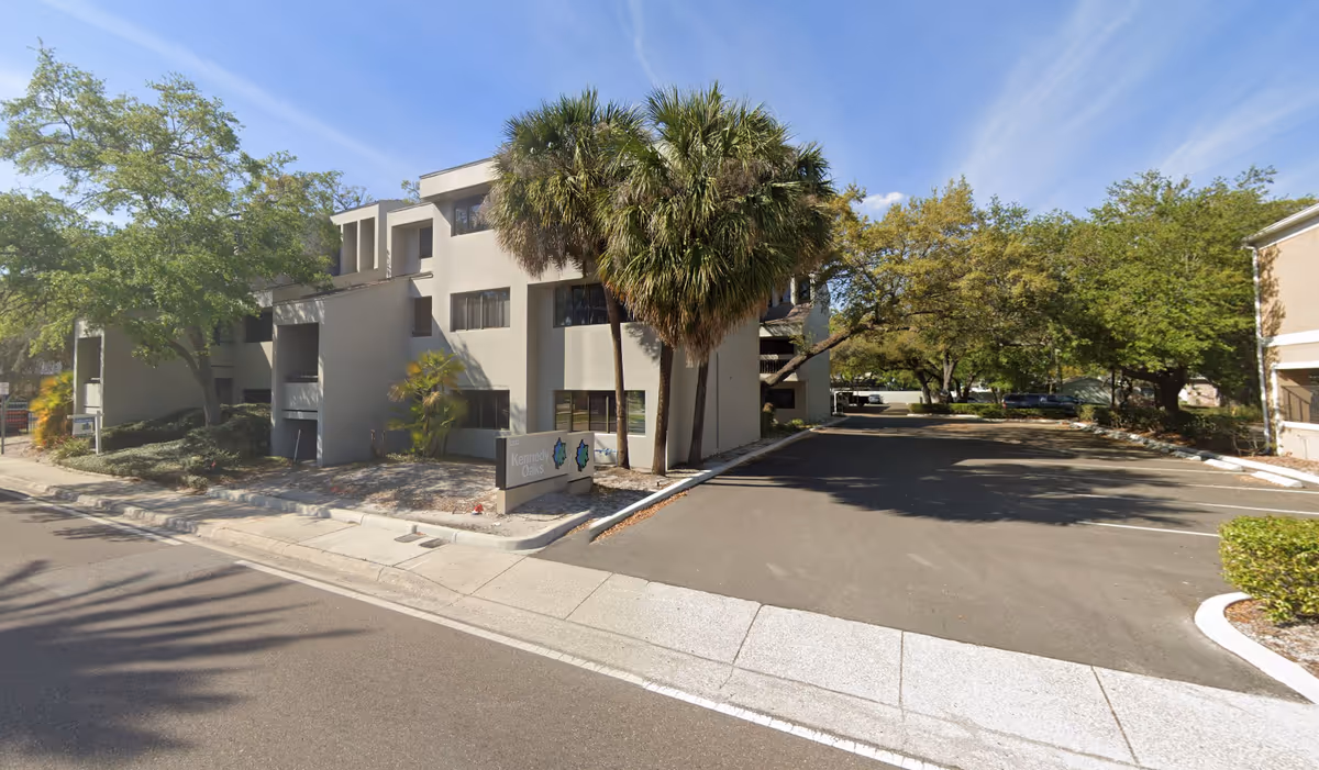 Front exterior of Granny Nannies Senior Home Care building with palm trees and a driveway.