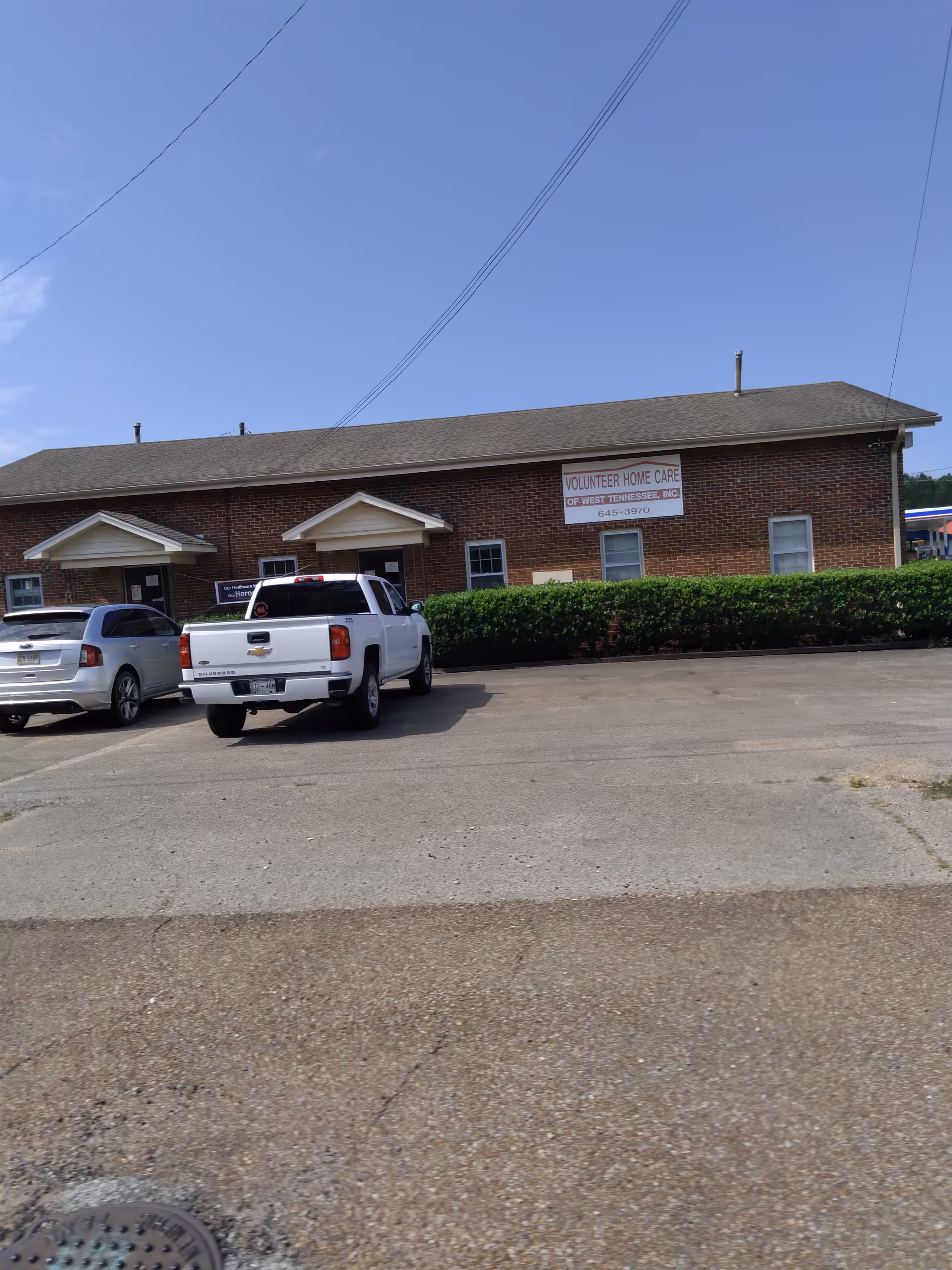 Exterior view of Volunteer Home Care building with parked cars in front.