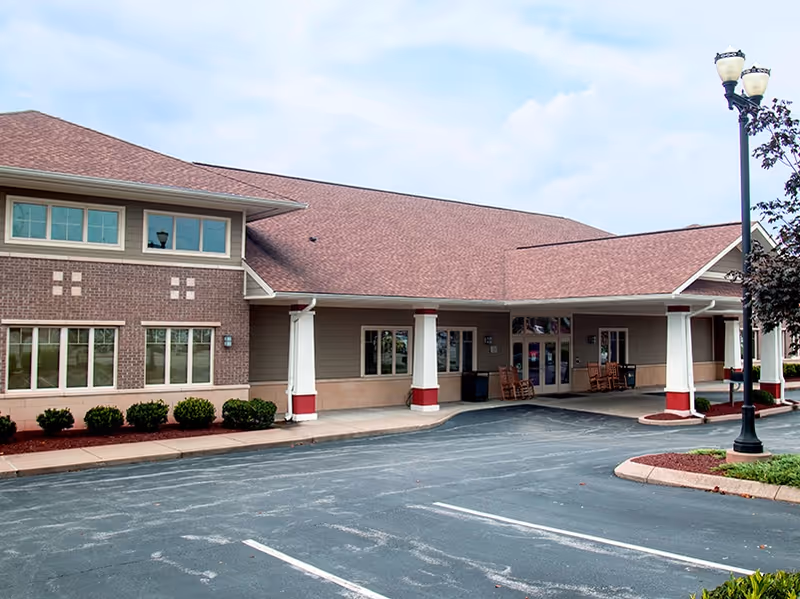 Exterior view of Hospitality House facility with a covered entrance and parking area.