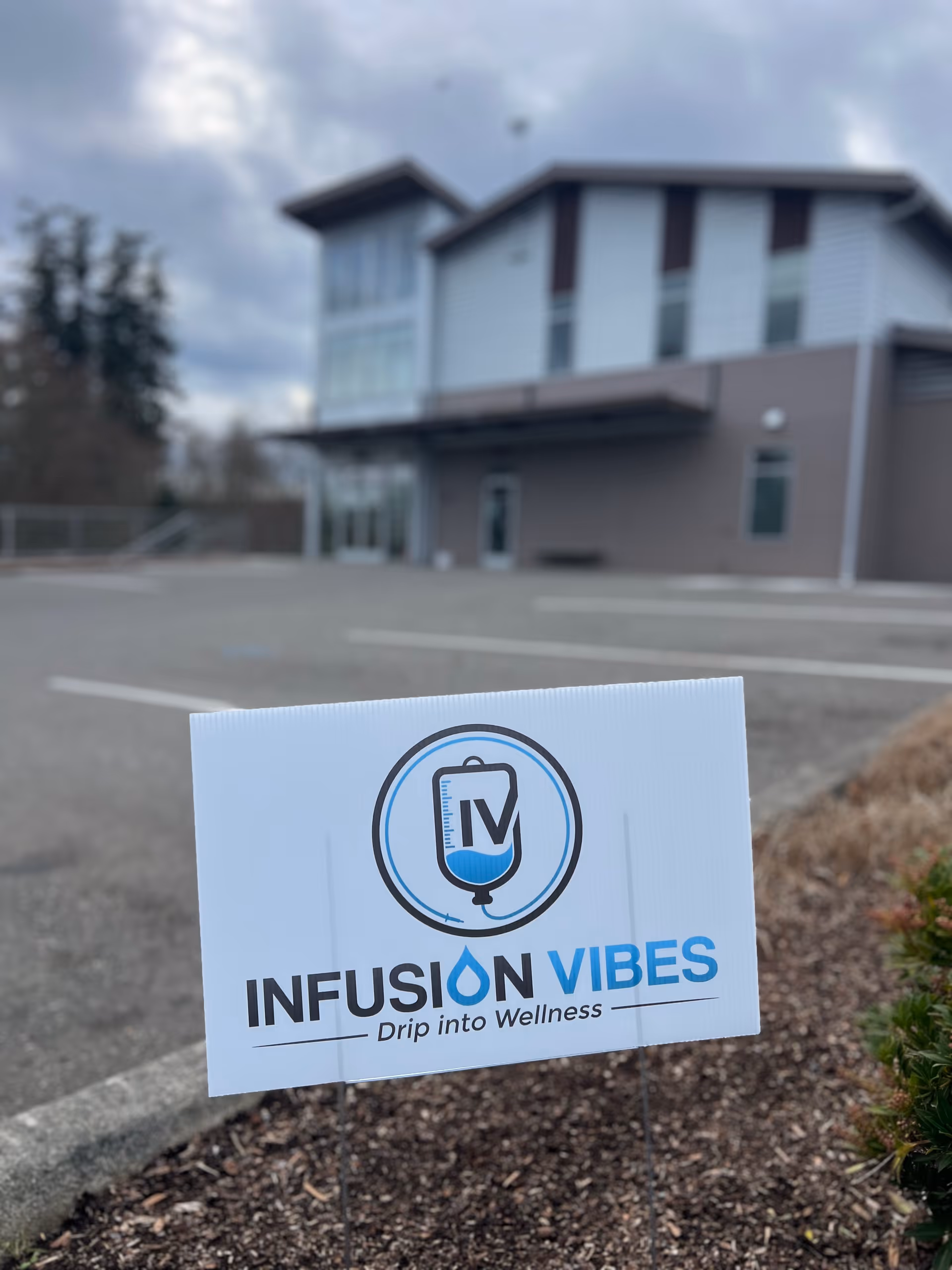 Exterior view of a modern building with Infusion Vibes sign in foreground.