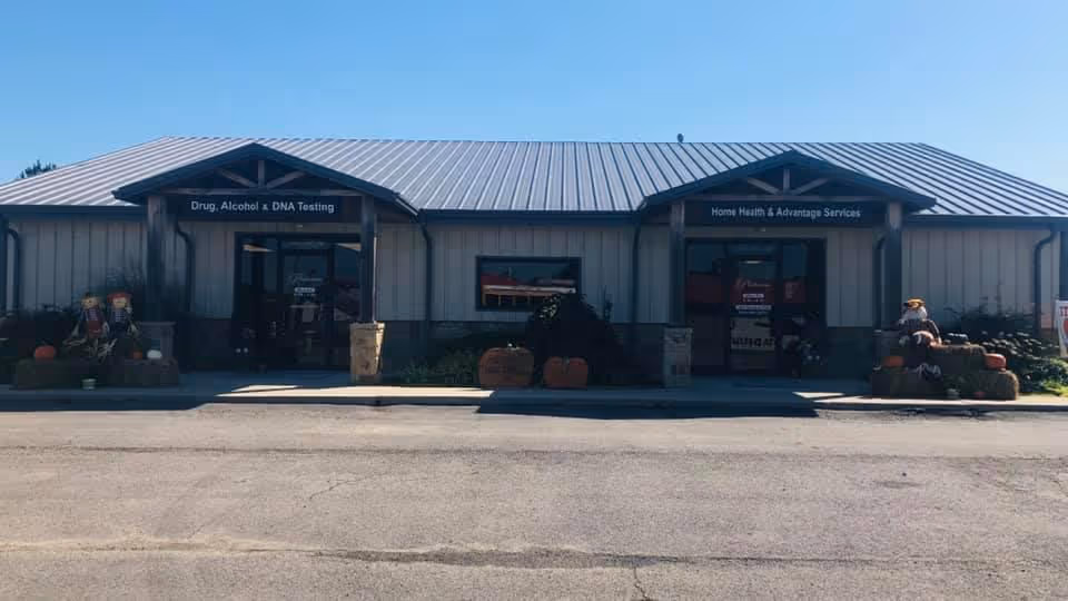 Front view of a single-story metal building with two entrances and fall pumpkin decorations.