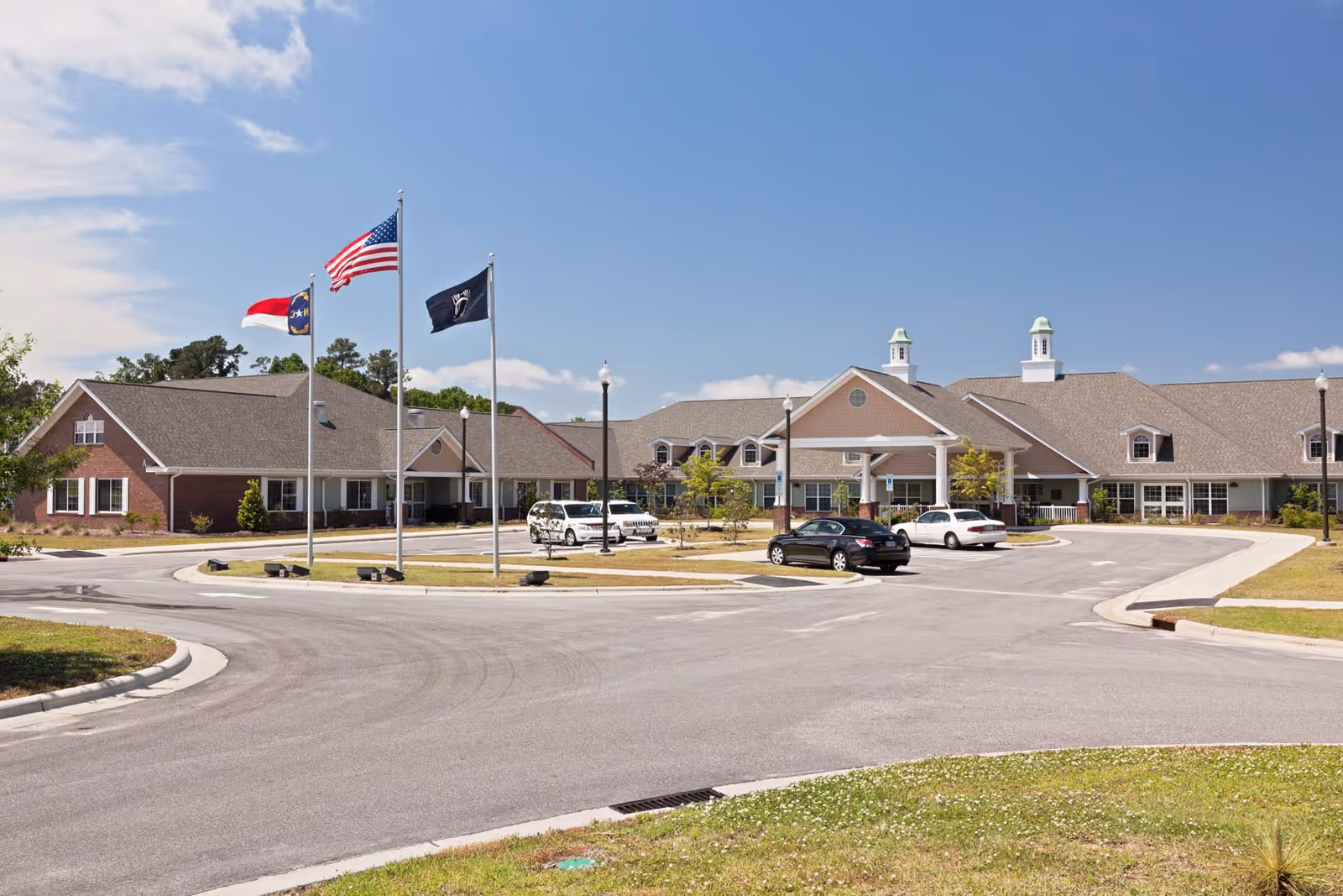 Exterior view of NC State Veterans Home-Kinston with flags and circular driveway.