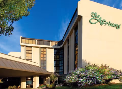 Exterior view of The Atriums Senior Living Community building with landscaped shrubbery.