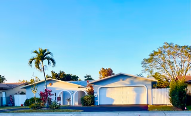Front exterior of a single-story facility with arched entryways and garages.