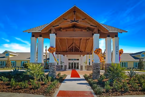 Front entrance of YOURLife of West Melbourne with red carpet walkway and columns.