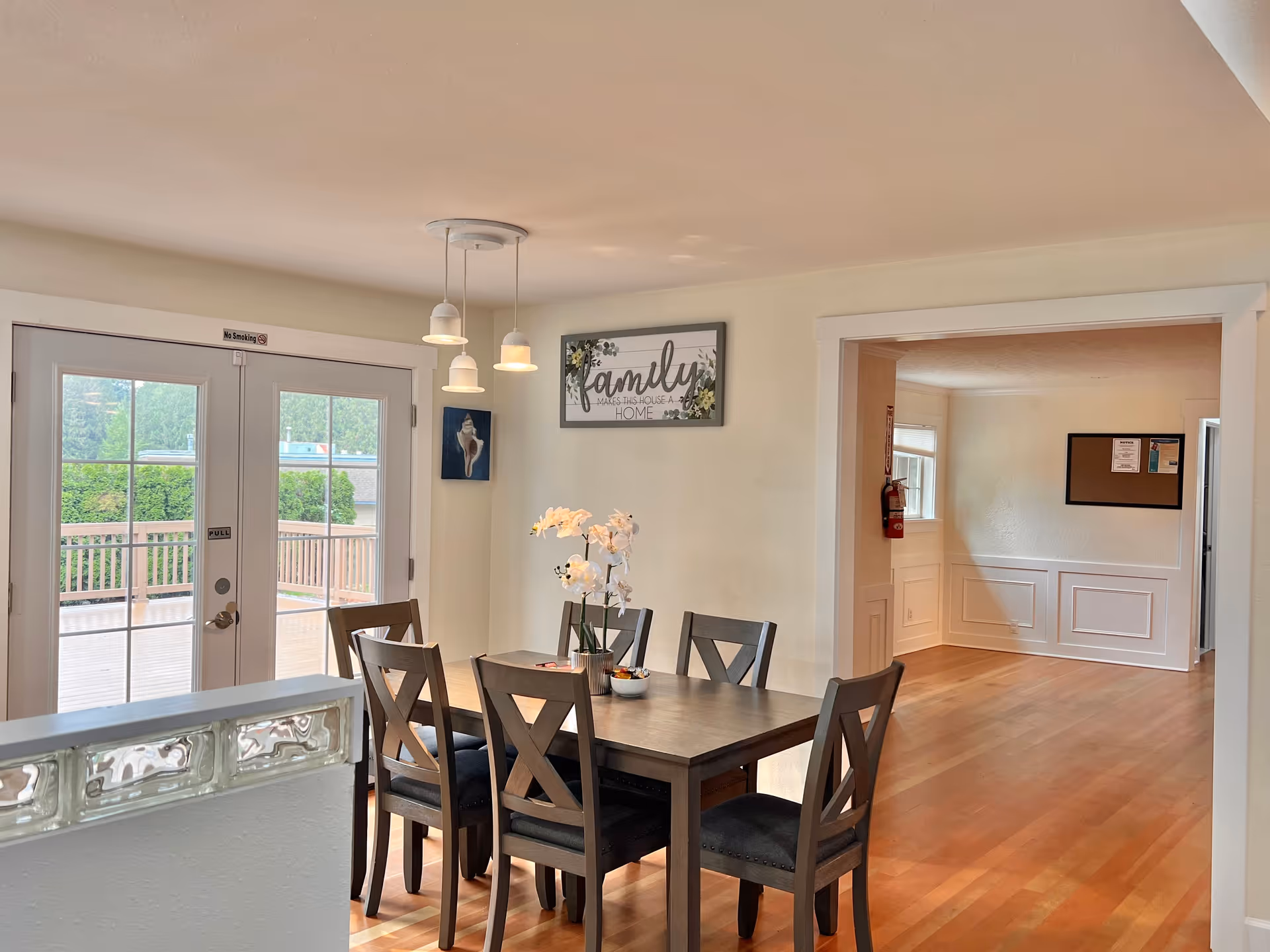 Dining room with a dark wood table, six chairs, and glass doors to an outdoor deck.