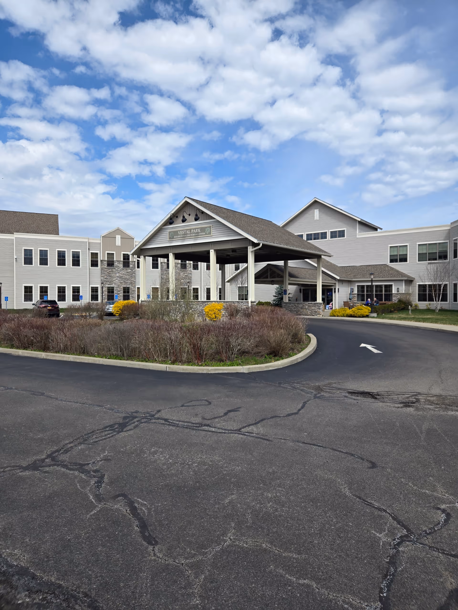 Exterior view of Vestal Park Rehabilitation and Nursing Center with driveway and entrance canopy.