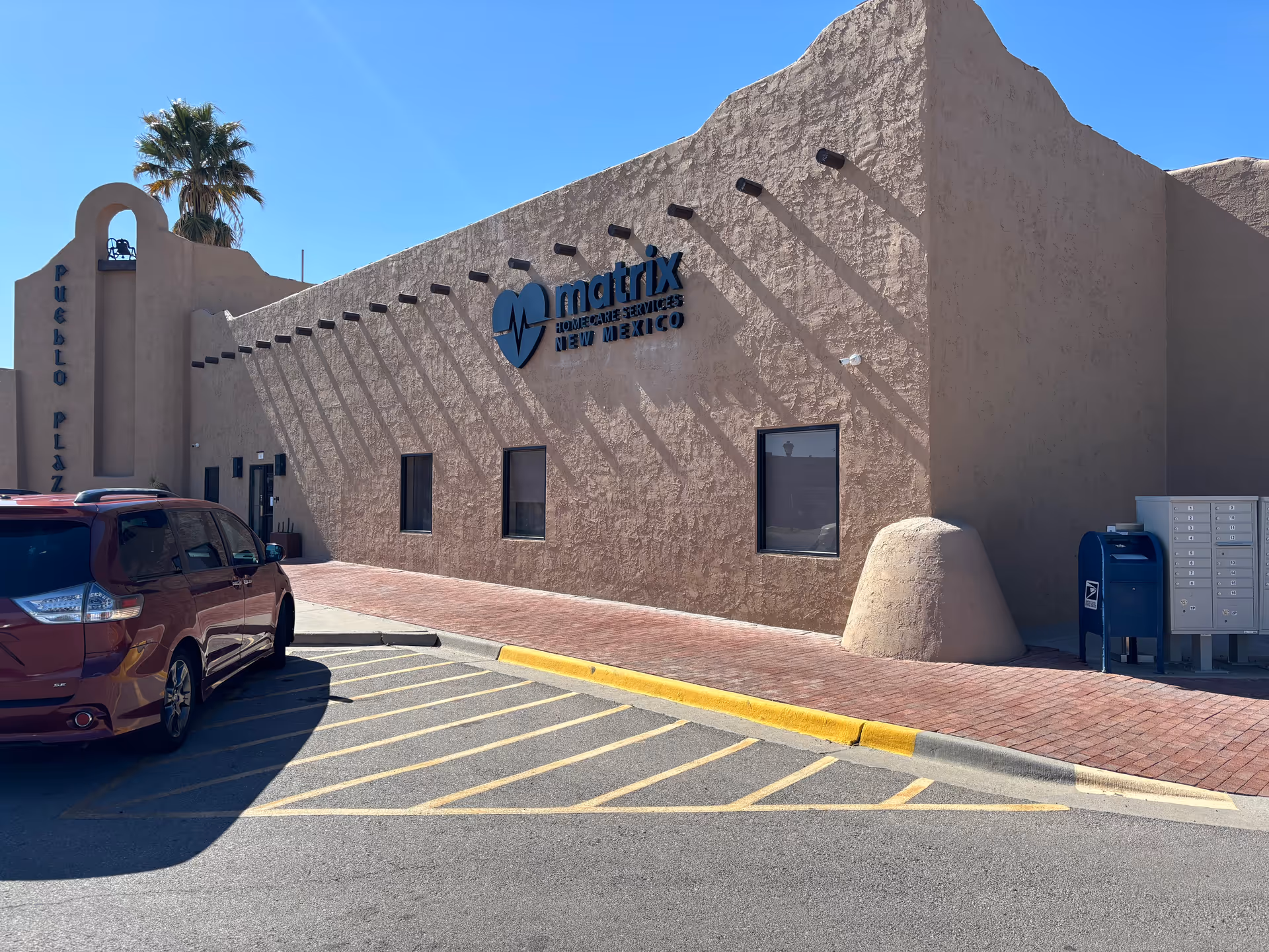 Front exterior of Matrix Home Care Services of New Mexico building with beige stucco and parking.