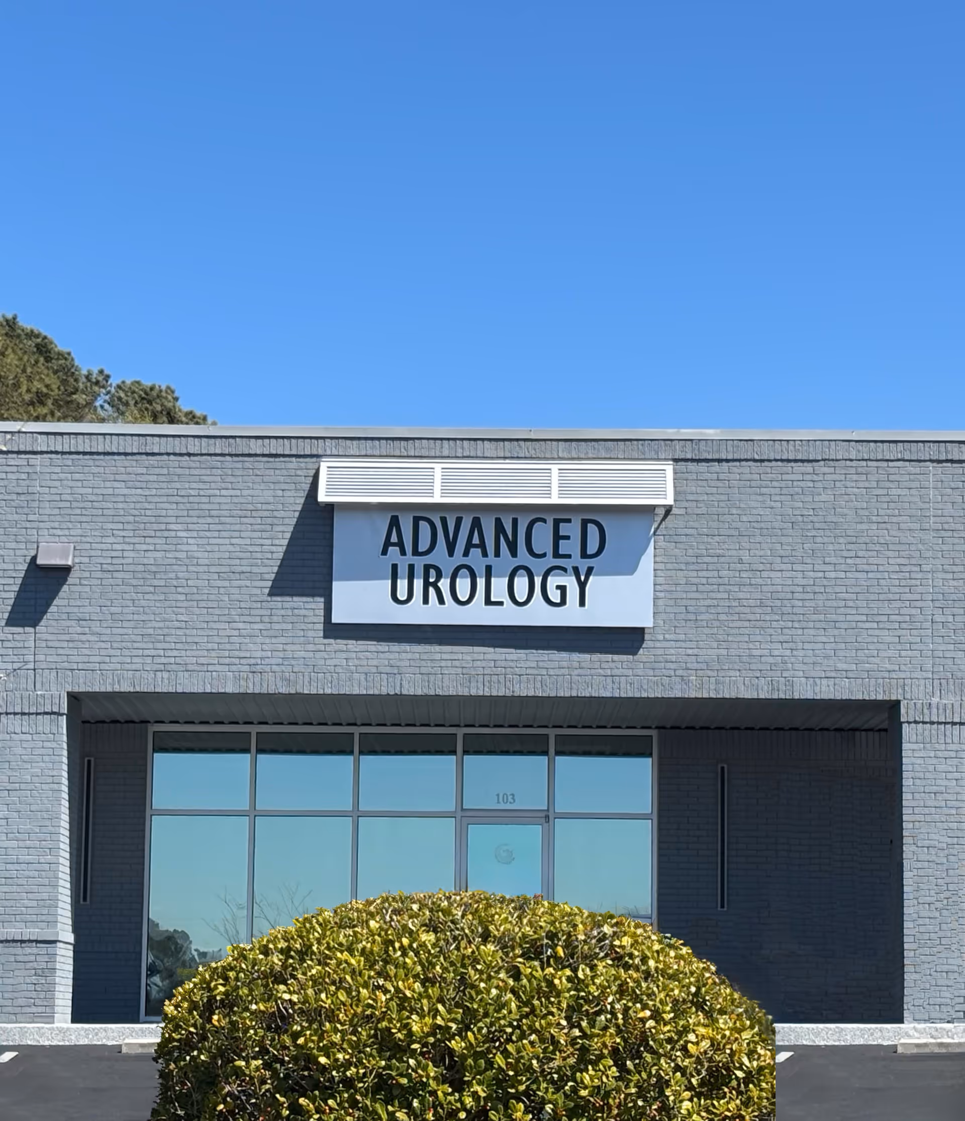 Gray brick medical building with large ADVANCED UROLOGY sign and glass entrance.