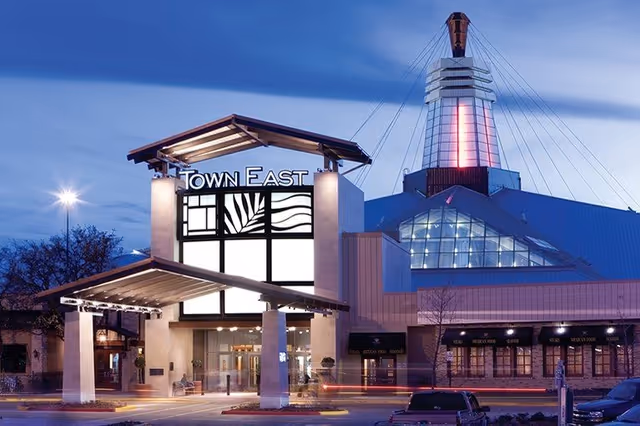 Exterior view of a modern shopping center with Town East signage at dusk