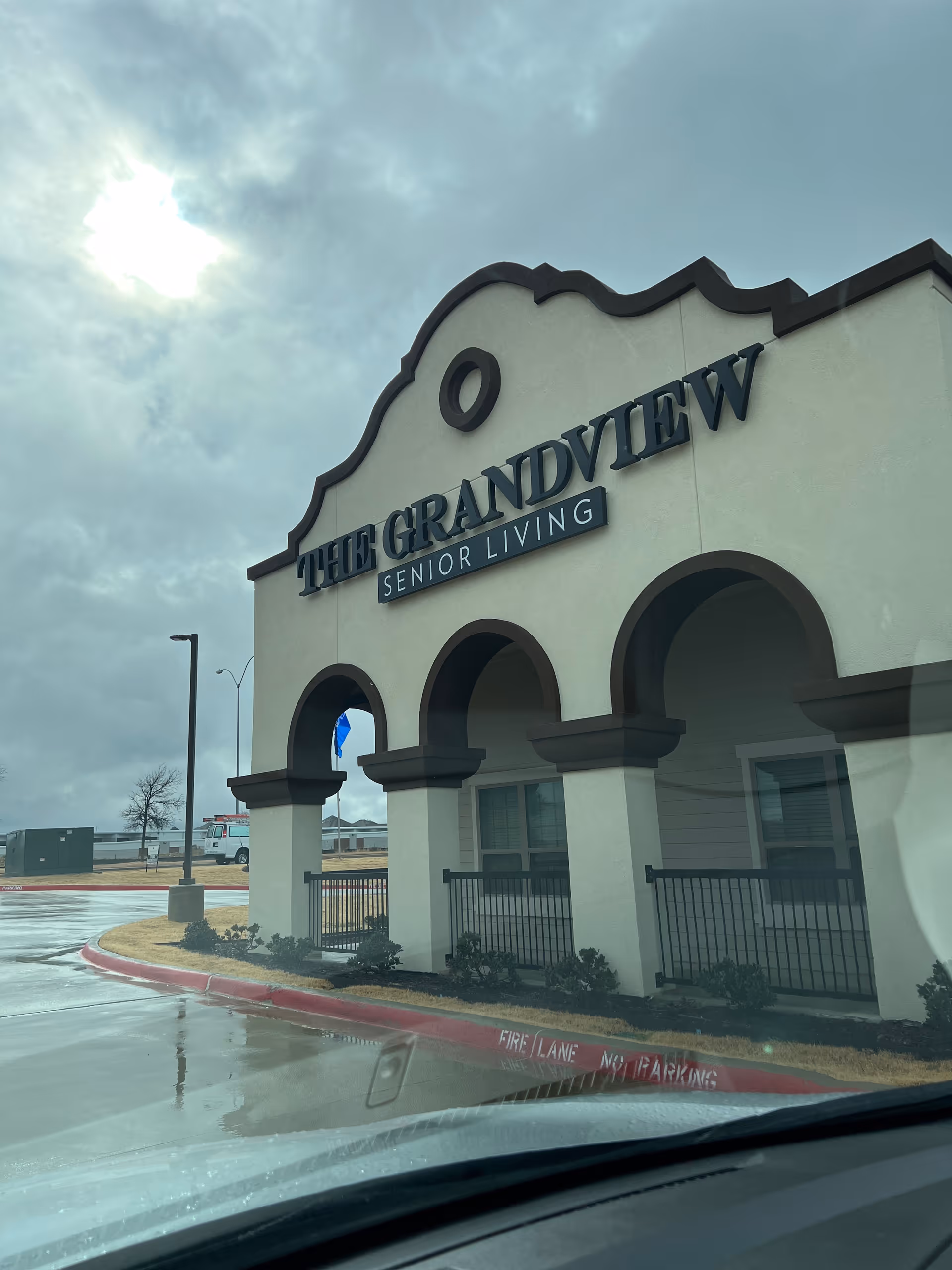 Front view of The Grandview Senior Living facility with arched entrance and sign.
