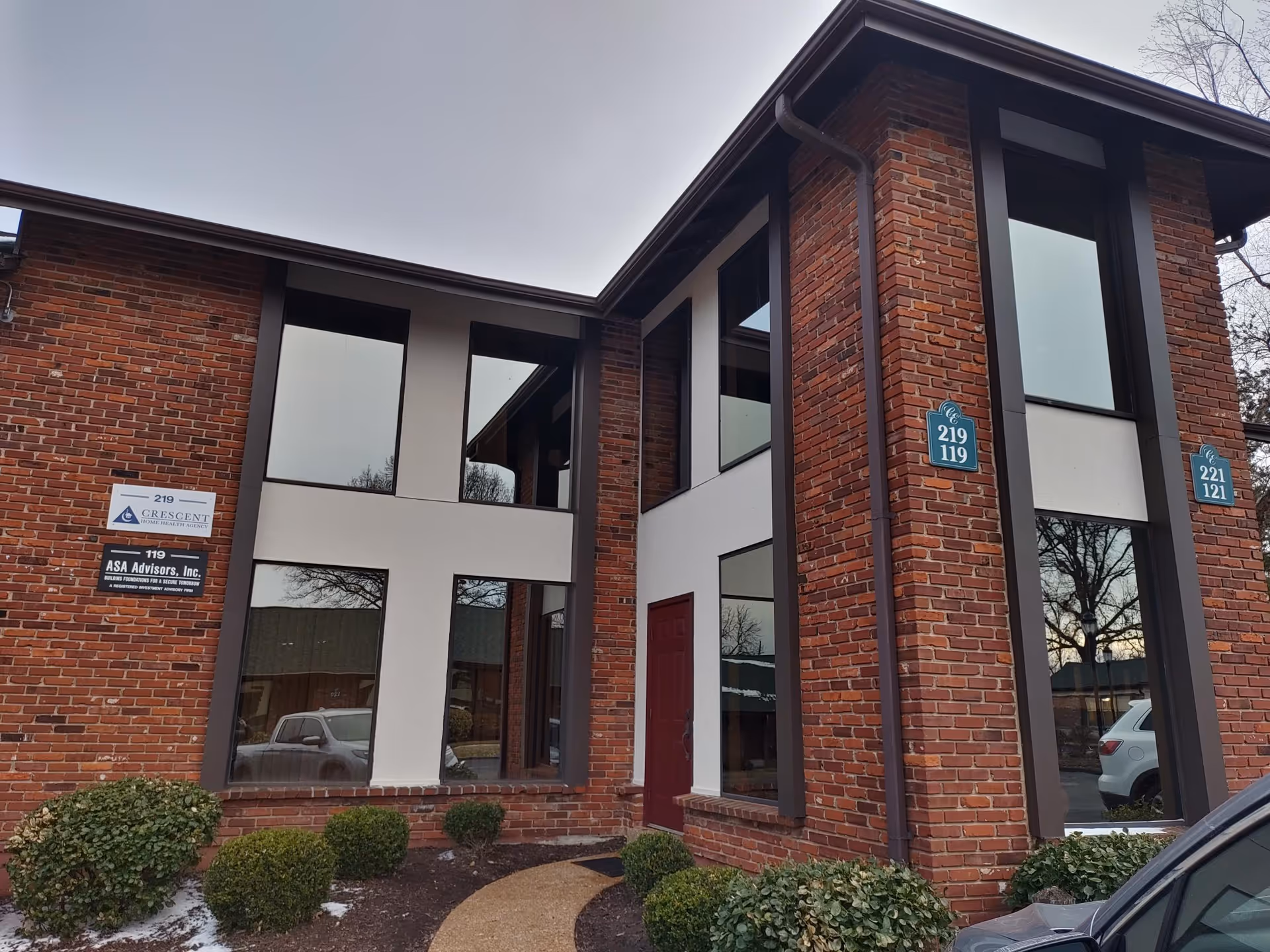 Exterior brick building with large windows, entrance, and Crescent Home Health Agency signs.