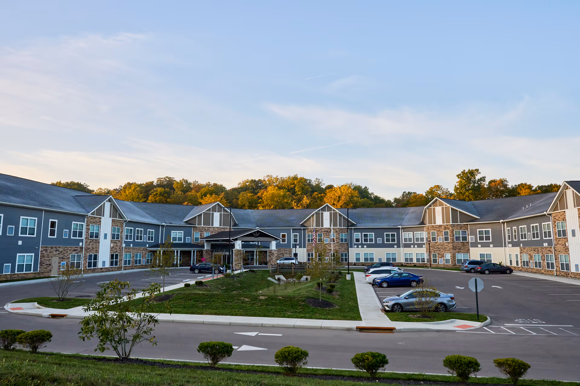 Exterior view of Harmony at Anderson senior living campus with parked cars and a circular driveway