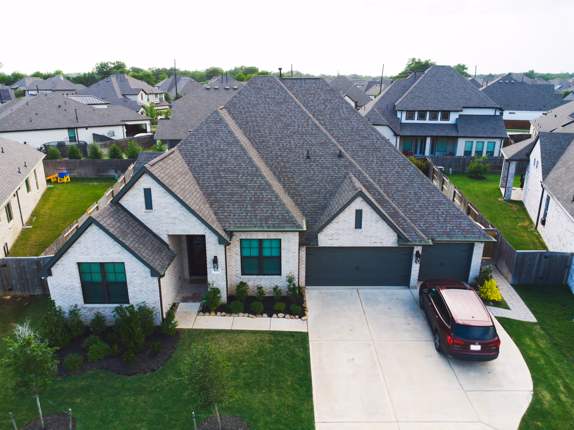 A modern suburban house with a two-car garage and neatly landscaped front yard.