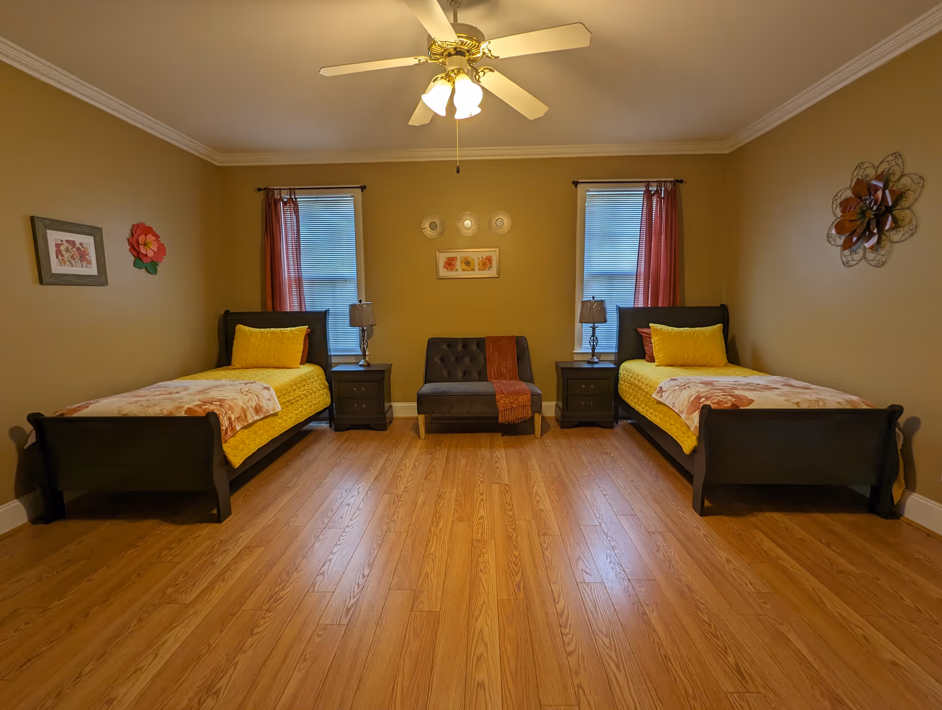 Two single beds flank a central loveseat with nightstands in a cozy beige bedroom.