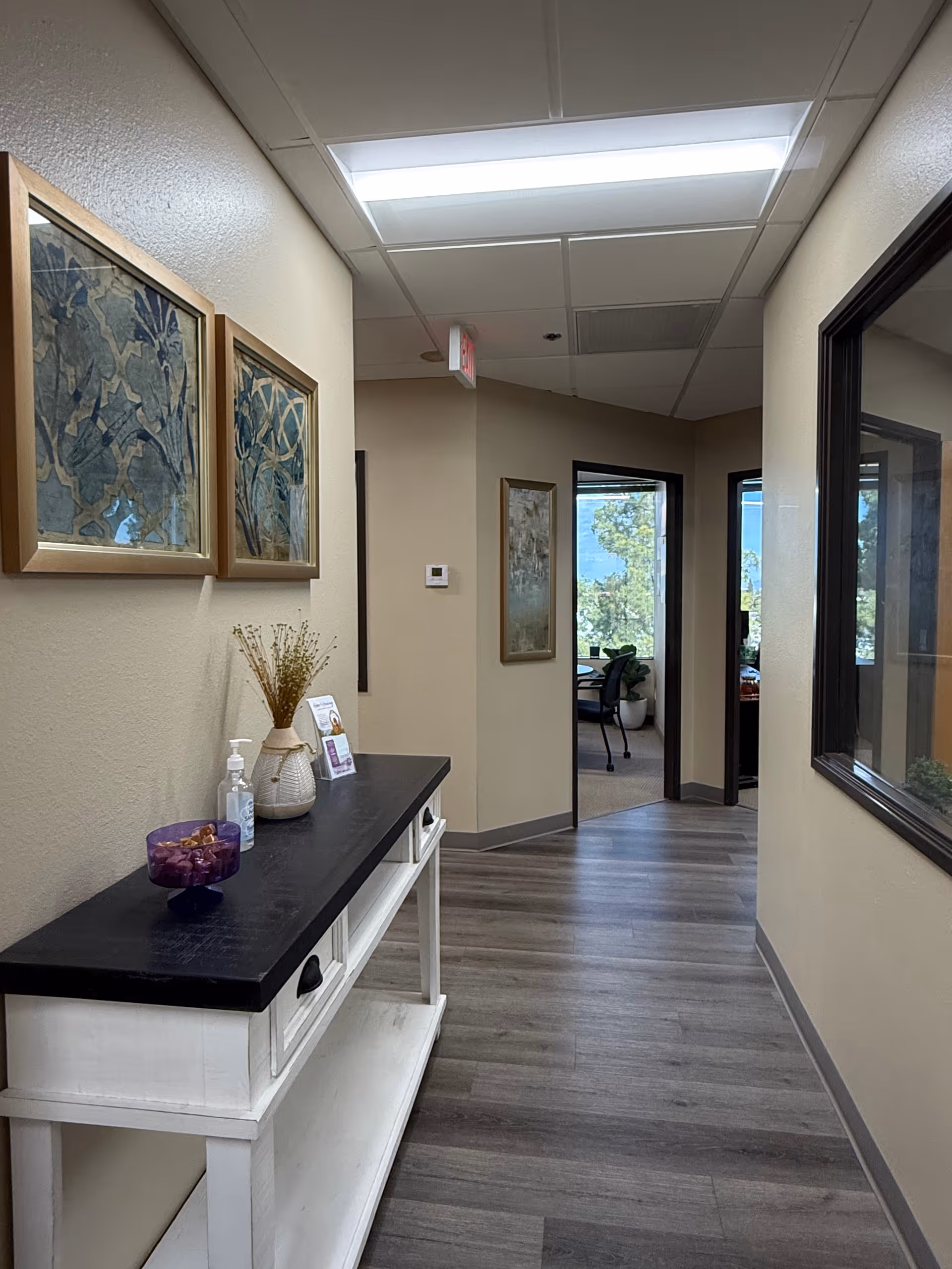 Interior hallway of a senior living facility with a console table and doorway to rooms