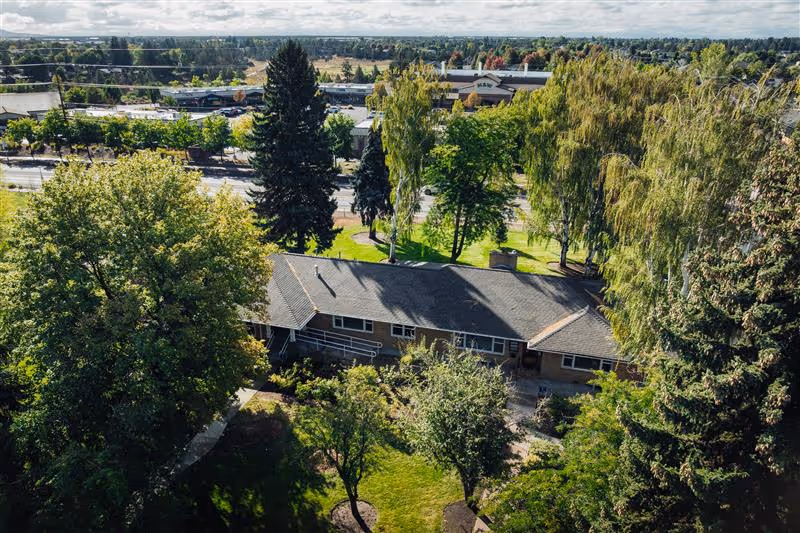 Aerial view of a single-story senior living facility surrounded by trees.