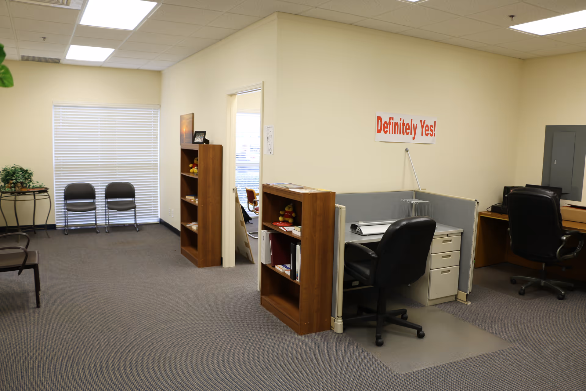 Office reception area with desks, cubicles, chairs, and Definitely Yes sign.