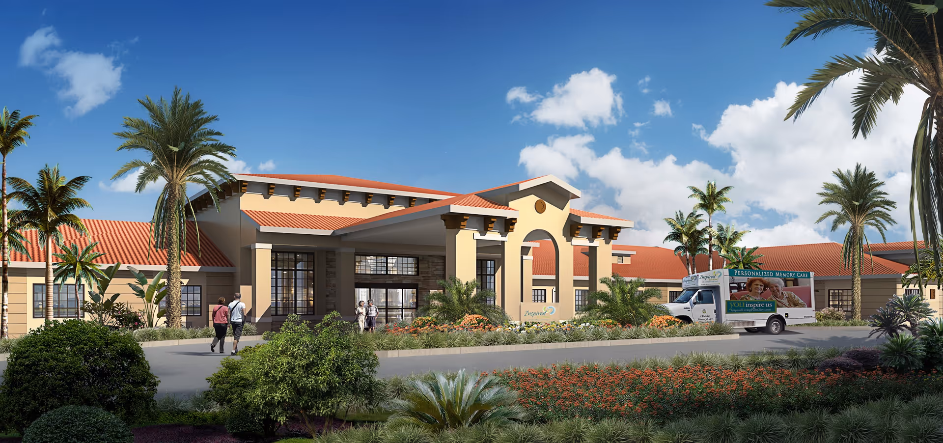 Exterior view of Inspired Living Bonita Springs facility with a clear blue sky, palm trees, landscaped garden, and a vehicle parked near the entrance. Several people are walking towards the building.