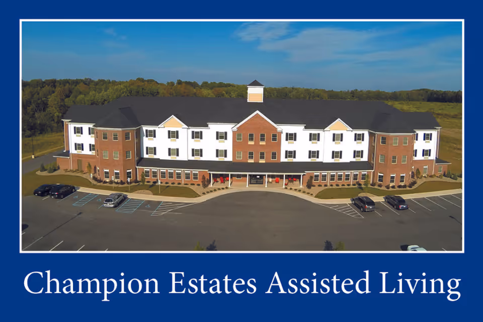 Exterior view of Champion Estates Assisted Living building with a parking lot in front.