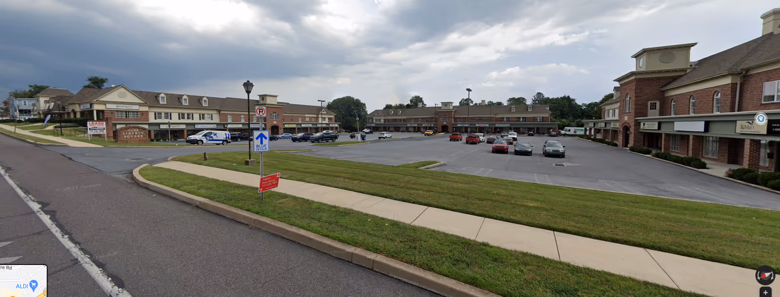 Exterior view of Comfort Care LLC facility with brick buildings, parking lot, and manicured lawn