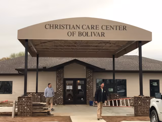 Entrance to Christian Care Center of Bolivar with two men standing outside.