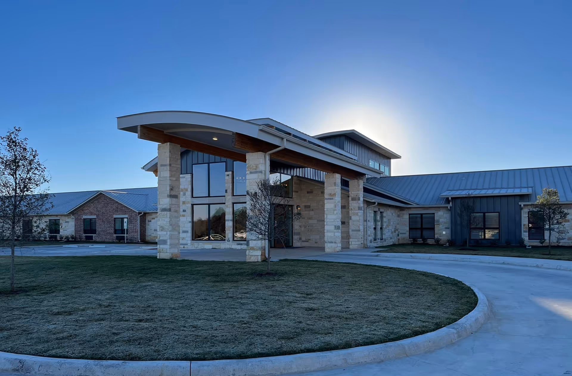 Modern stone entrance with large windows and a metal roof at The Brixton at Horseshoe Bay.