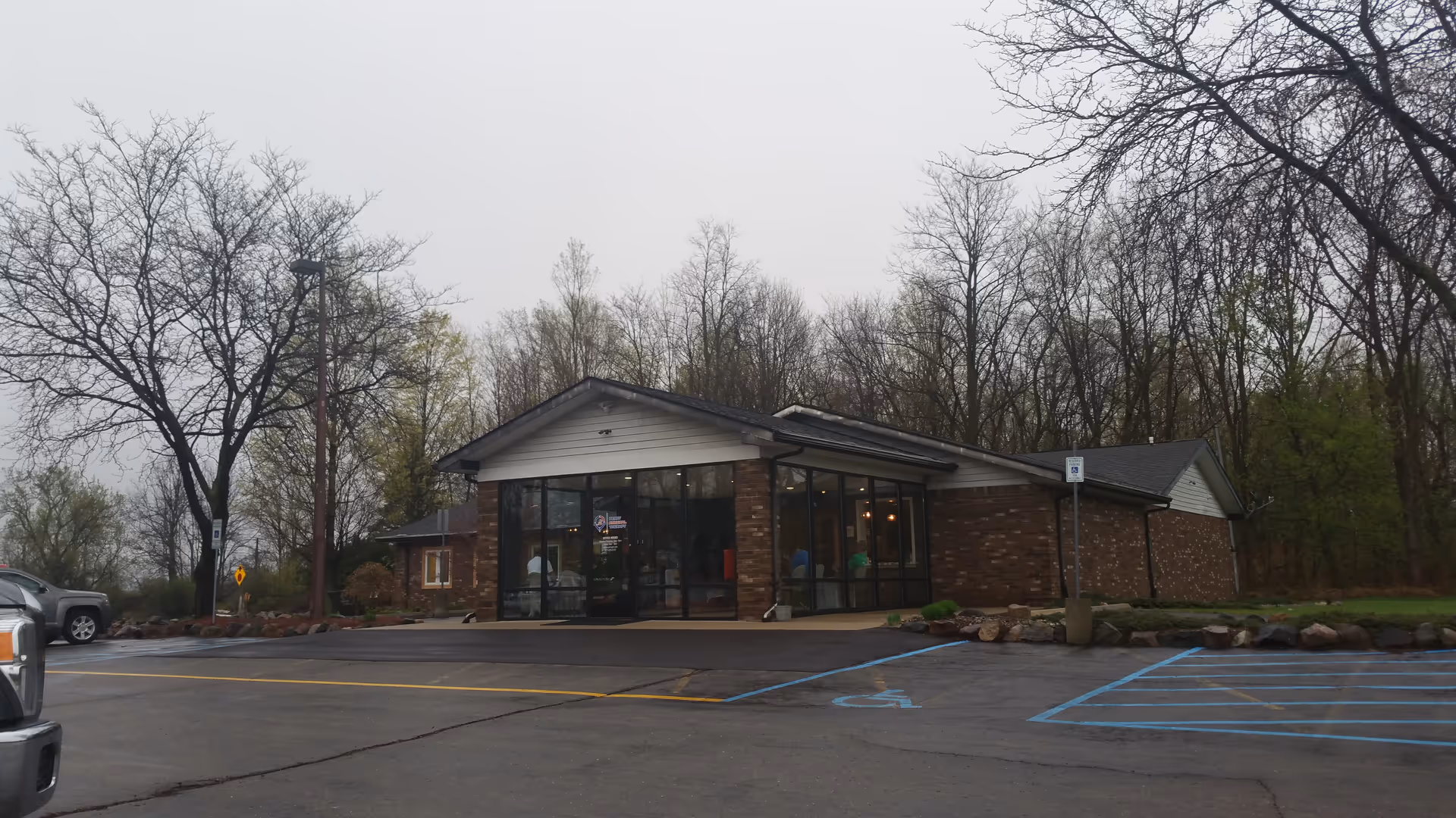 Exterior view of Perry Physical Therapy Inc building with glass entrance and parking lot.