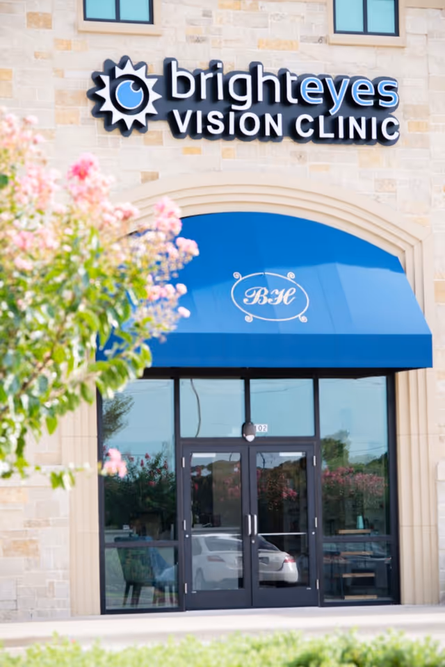 Stone building exterior with Bright Eyes Vision Clinic sign and blue awning.