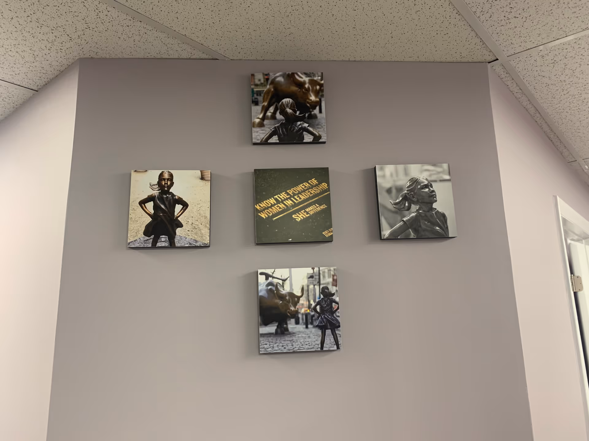 Five square canvases arranged in a cross on a gray wall.